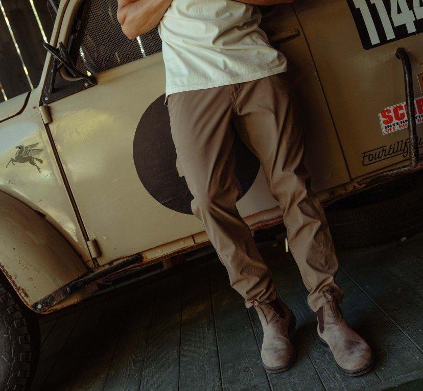 A man wearing KUHL pants standing in front of a truck