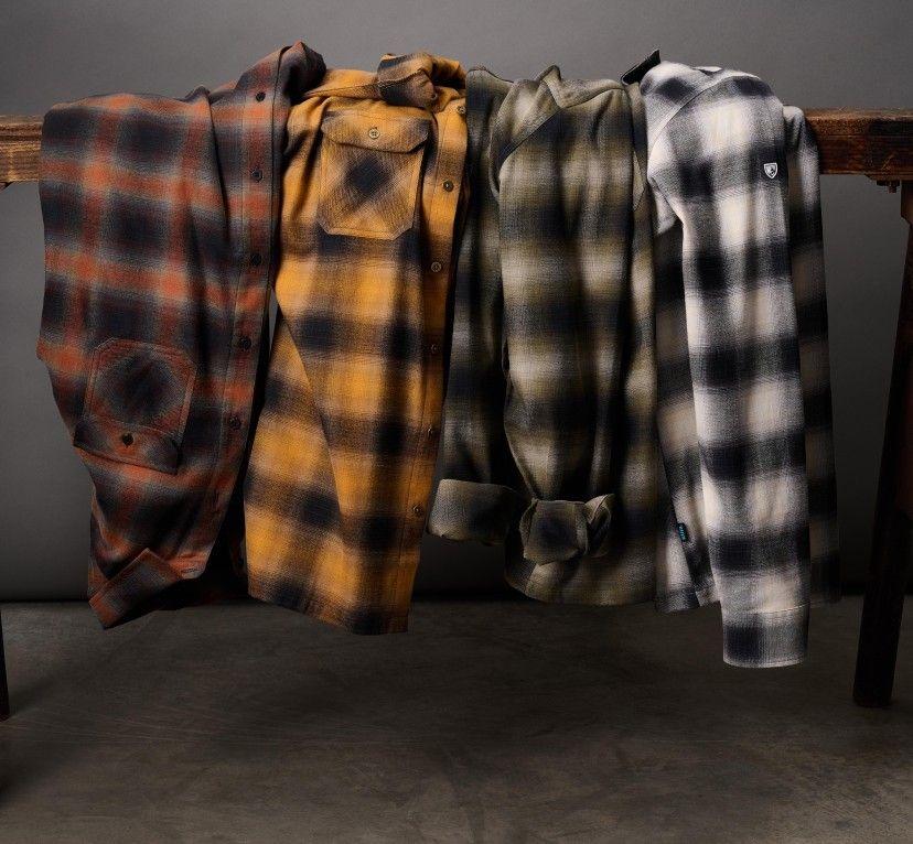 A collection of Men's KUHL flannels draped over a sawhorse