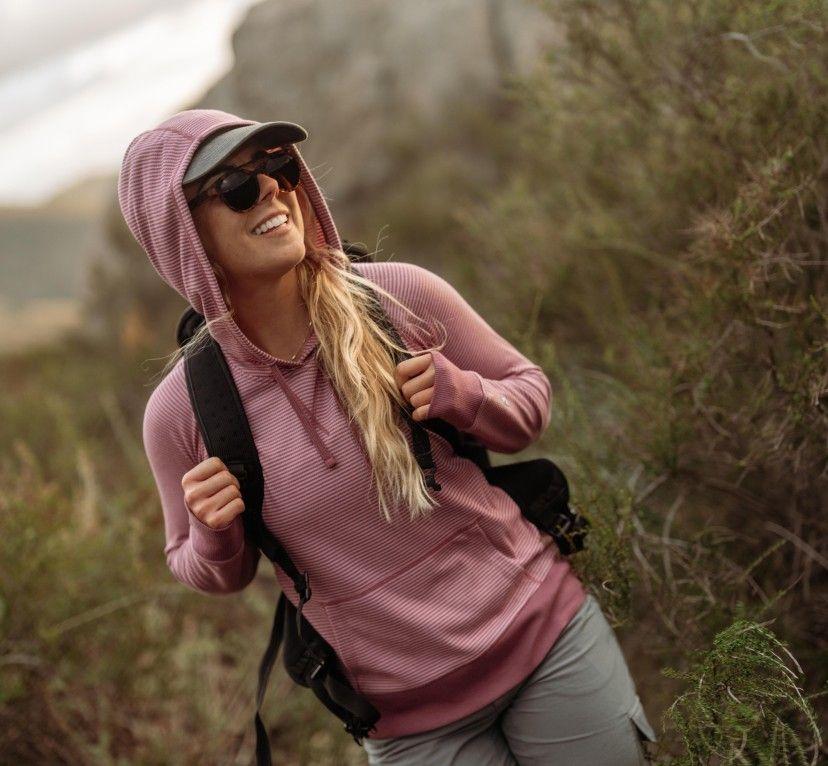 A woman on a hike wearing the KUHL Stria Pullover