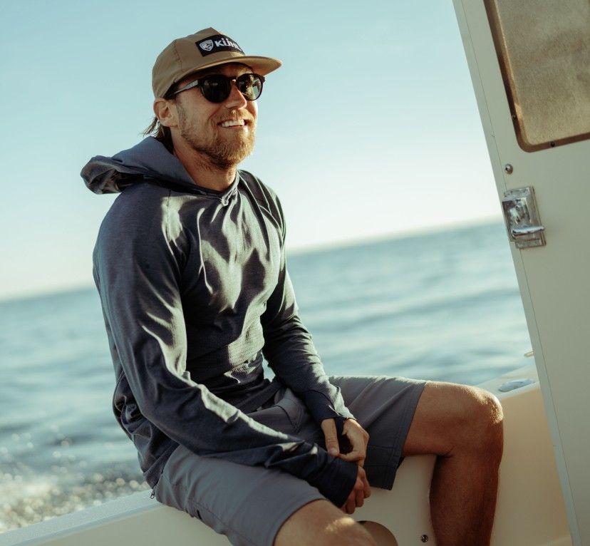 A man on a boat wearing a KUHL Eclipser Hoody
