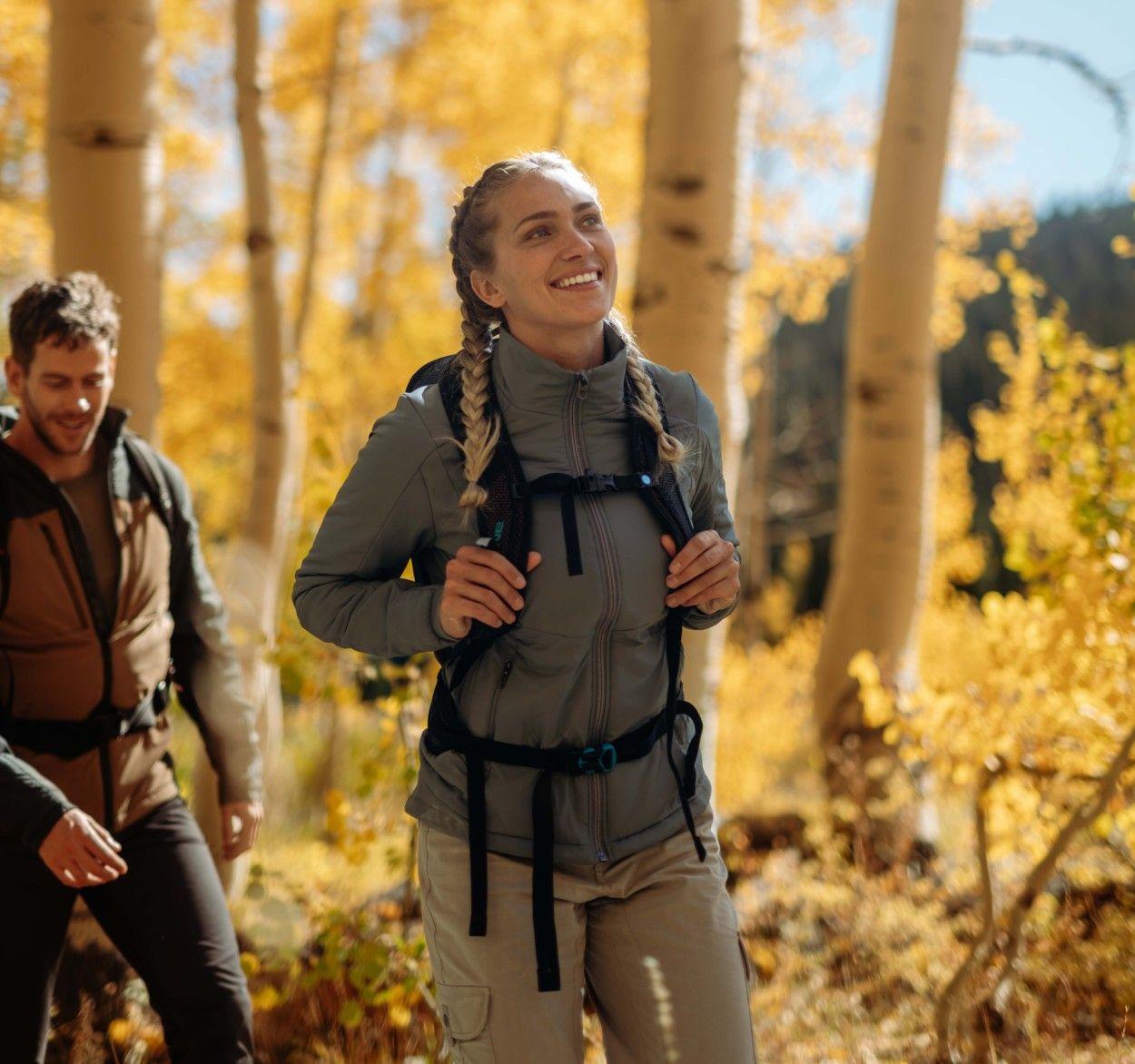 A woman having fun in the forest wearing a Kühl Aktivator® Jacket.
