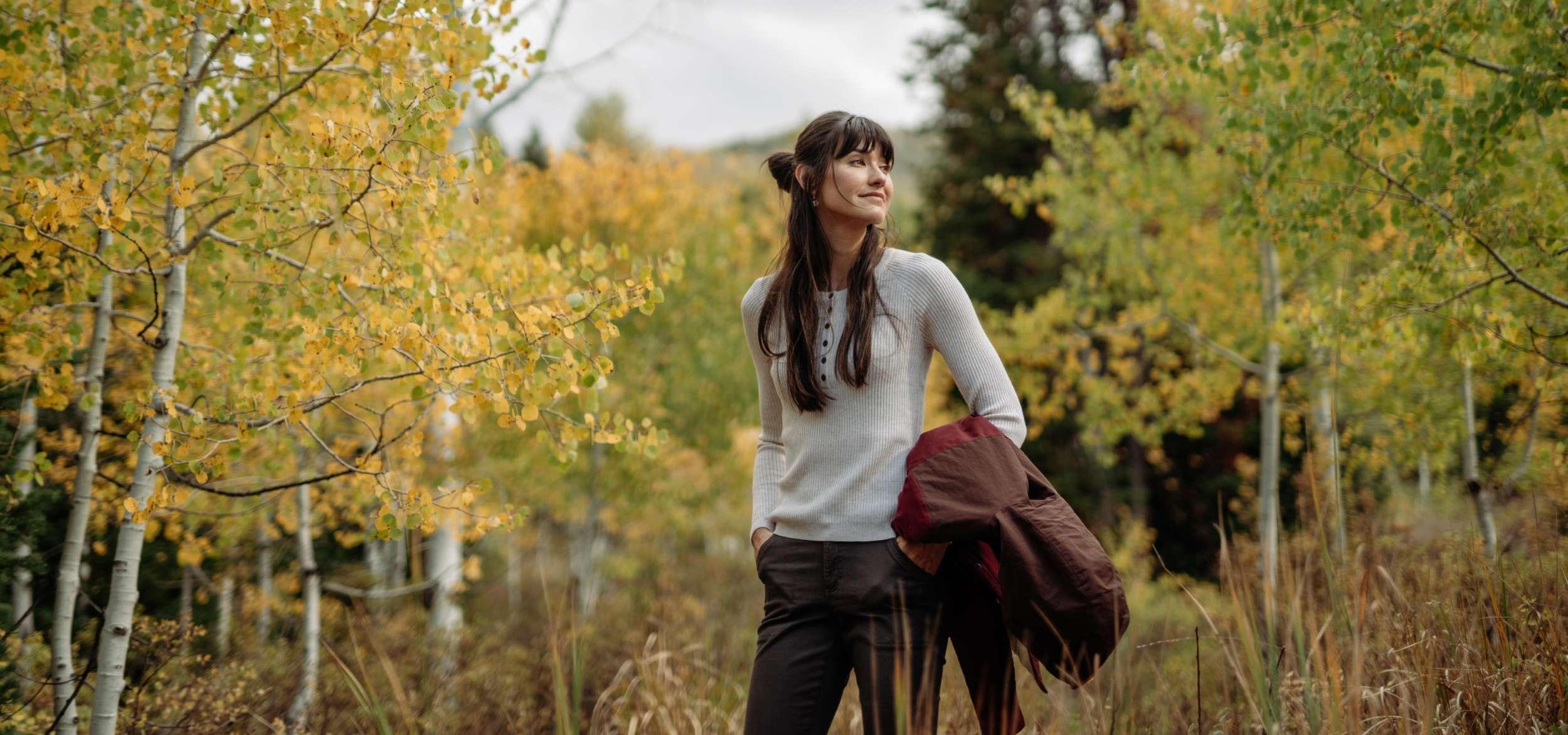 A woman in the woods wearing a Gemma™ Sweater