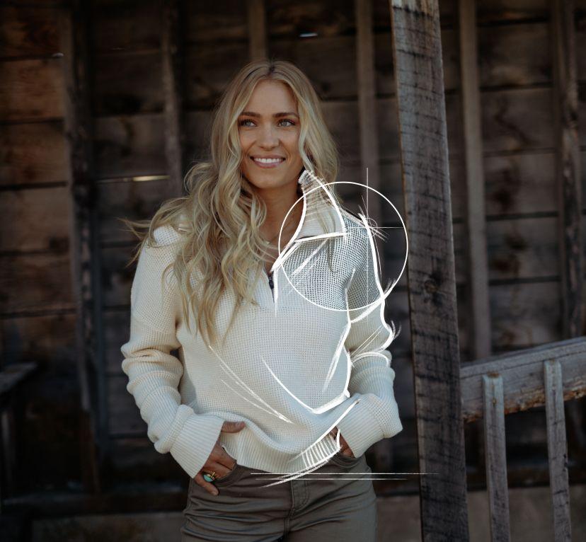 A woman smiling and wearing the Kühl Norda™ 1/4 Zip Sweater.