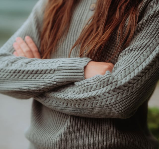 A woman wearing a Kühl Norda™ 1/4 Zip Sweater.